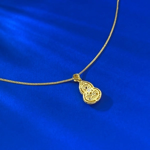 Macro detail of a golden gourd pendant with intricate hollow wave patterns and a diamond