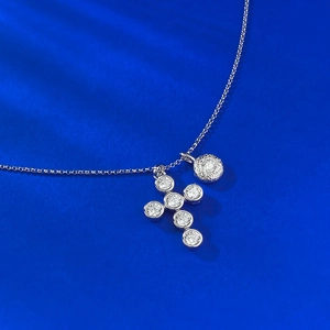Collier en argent S925 avec pendentif croix à bulles et petit disque sur fond bleu