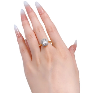 Elegant emerald cut halo engagement ring in gold with sparkling accent stones on hand