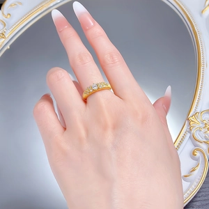 Macro shot of gold-plated brushed texture ring with sparkling white zircon stones