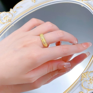 Detailed macro view of a gold-toned clover lantern ring with intricate vintage carvings