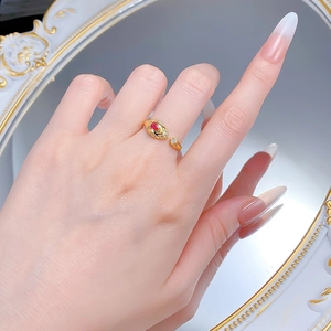 Close-up of S925 silver gold snake ring with red oval gemstone and pavé diamonds