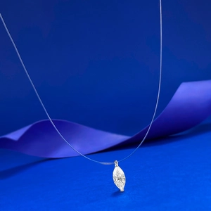 Vue macro d'un pendentif cristal marquise sur fil invisible avec ruban de soie