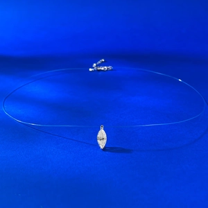 Gros plan d'un pendentif en zircone marquise sur un collier à fil de nylon invisible