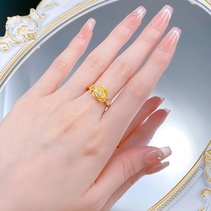 Detail of a brushed gold rose flower ring with a sparkling diamond center for women