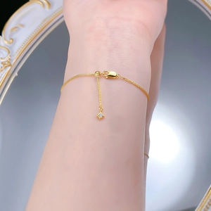 Close-up of minimalist gold star pendant bracelet worn on wrist with adjustable chain