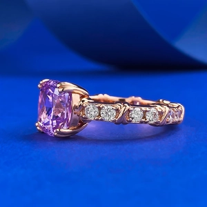 Macro shot of cushion-cut lavender gemstone ring with rose gold band and side diamonds