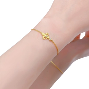 Elegant gold fleur-de-lis bracelet with white zircon stones worn on woman wrist