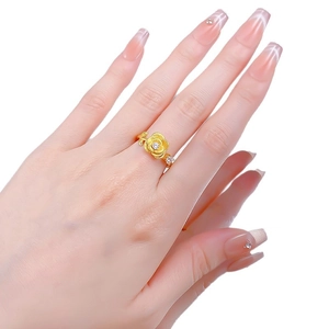 Elegant gold rose ring with a center zircon on a model's hand with white background