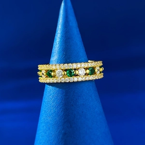 Detailed view of S925 silver emerald and zircon ring set in rose gold on a blue stand