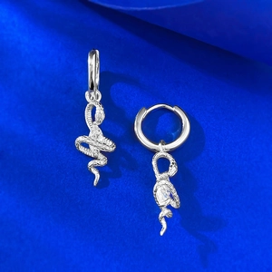 Macro shot of silver snake earrings with marquise zircon stones and scale textures