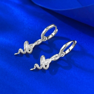 Macro view of S925 silver snake earrings with detailed scale texture and hoop closure