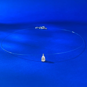 Détail macro du pendentif en forme de goutte sur un collier en fil de pêche invisible