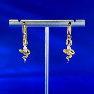 Macro detail of snake drop earrings with marquise-cut stone on silver display