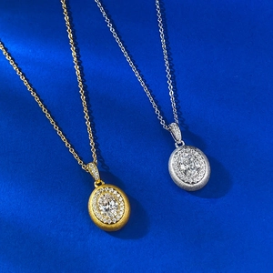 Detailed close-up of oval brushed S925 silver pendants with halo crystals on blue background