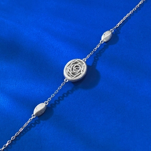 Détail d'un bracelet vintage en argent S925 avec breloque rose évidée et perles brossées