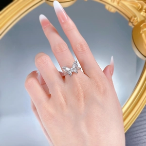 Macro detail of S925 silver butterfly ring with sparkling crystals on a mirror