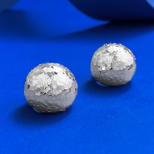 Detail view of S925 sterling silver ball earrings featuring hammered textured facets