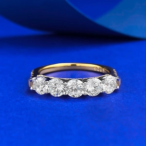 Vue macro d'une bague en argent S925 avec cinq zircons ronds sertis griffes dorées