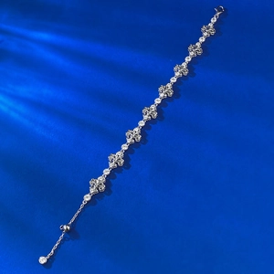 Macro shot of S925 sterling silver iris flower bracelet with adjustable clasp on blue backdrop