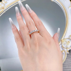 Détail d'une bague en argent S925 avec cinq zircons sur un anneau doré poli