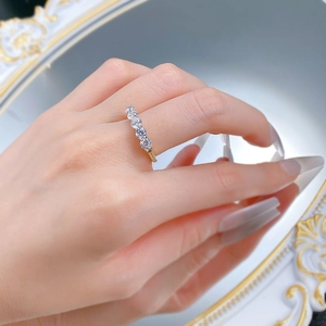 Détail d'une bague en or avec cinq pierres de zircone rondes portée par un mannequin