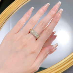 Detail of a two-tone ring with emerald-cut square diamonds and side pavé setting