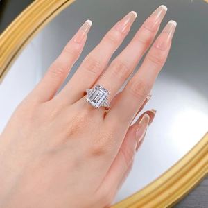 Three-stone S925 silver ring featuring emerald-cut center stone on a model hand