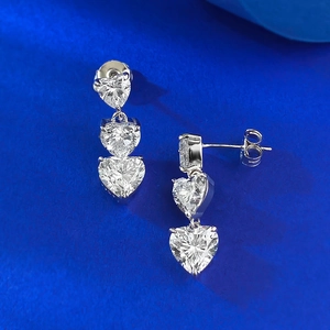 Macro shot of triple heart-shaped zircon drop earrings in S925 silver on velvet