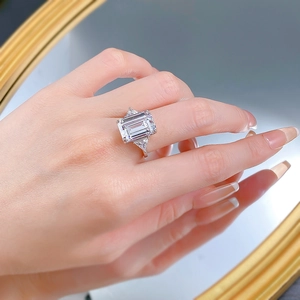 Macro view of emerald cut white gemstone ring with S925 silver three-stone setting