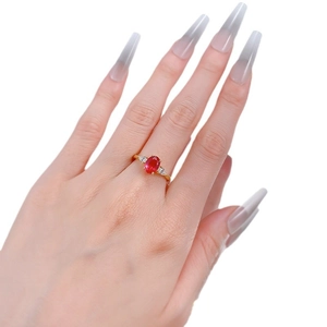 Eleganter Goldring mit ovalem Rubin und seitlichen Diamanten an der Hand getragen