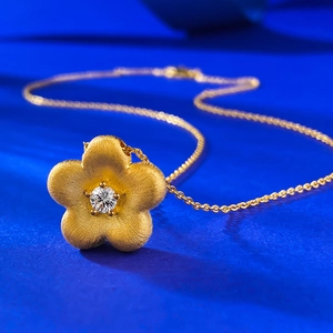Collier élégant avec pendentif fleur dorée, texture brossée et pierre étincelante