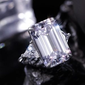 Macro shot of emerald-cut rectangular diamond ring with triangle side stones in silver