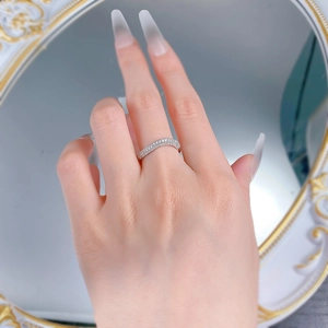 Macro shot of a sparkling S925 silver wavy band ring with pavé diamonds on finger