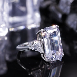 Macro shot of 925 silver ring with emerald-cut main stone and triangular side diamonds