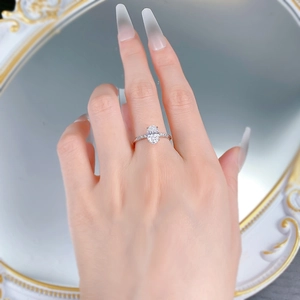 Detail of an oval-cut gemstone ring with micro-paved band worn on a finger