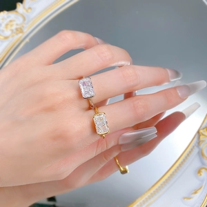 Close-up of elegant gold and silver rings with rectangular emerald cut clear gemstones