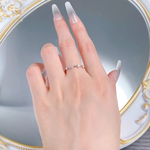 Gros plan sur une bague fine en argent S925 ornée de quatre zircons ronds brillants