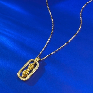 Vue détaillée du pendentif Vajra doré serti de cristaux sur un fond bleu vibrant