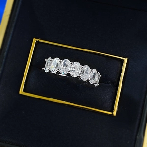 Gros plan de sept pierres ovales étincelantes serties sur une bague dans un écrin noir