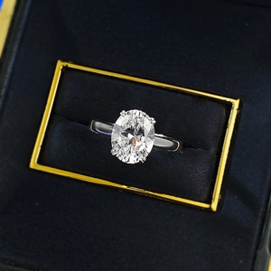 Macro view of a 4-carat oval cut gemstone ring in a classic four-prong silver setting