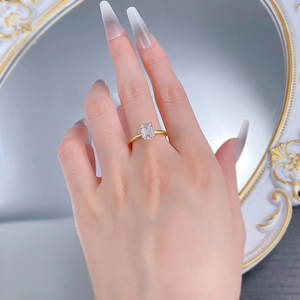 Macro view of emerald cut gemstone ring with gold band and classic four-prong setting