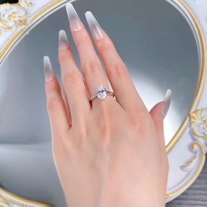 Close-up of 4 carat oval cut gemstone ring with four-prong silver setting on hand