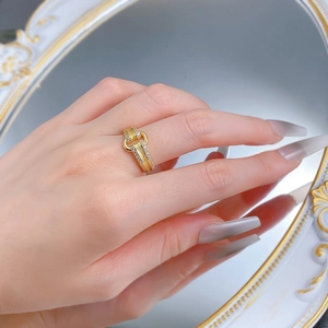 Detailed view of matte brushed gold rings with zircon accents on a hand