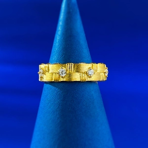 Macro view of gold brushed S925 silver ring featuring vertical textures and white gemstones