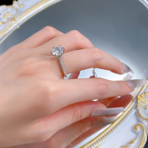 Détail d'une bague en argent S925 avec solitaire rond à six griffes et anneau serti pavé