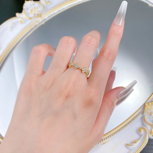 Detail of a gold S925 silver four-leaf clover ring with sparkling zircon pavé on fingers