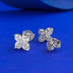 Macro shot of silver S925 four-leaf clover stud earrings with clear sparkling crystals