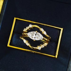 Macro detail of marquise cut solitaire ring set with gems in blue velvet box