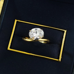 Oval cut moissanite ring with twisted band inside a velvet blue jewelry box